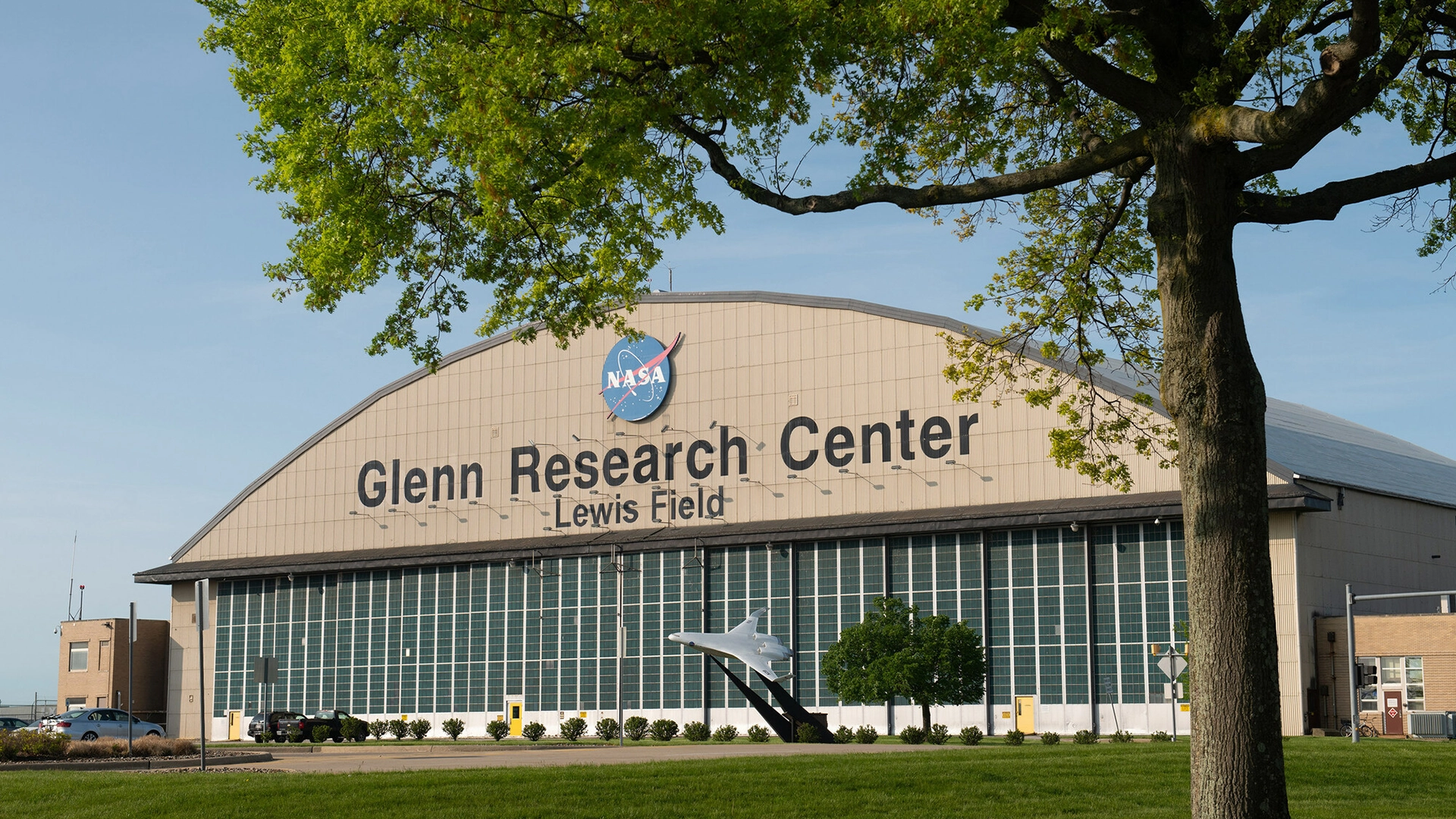 Exterior of NASA Glenn Research Center Lewis Field with a plane monument and NASA logo.