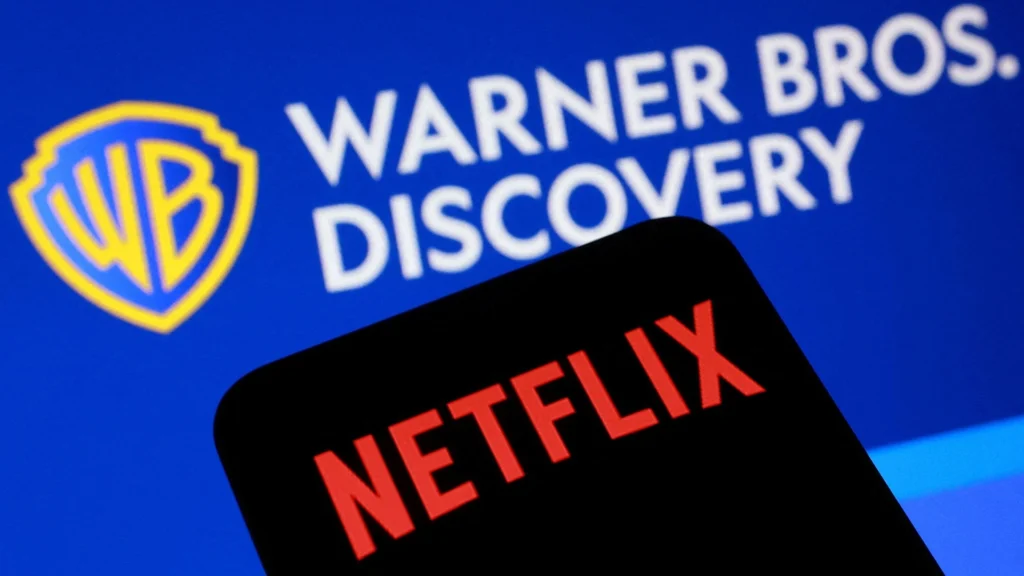 Netflix and Warner Bros Discovery – Tumisang Bogwasi Netflix logo on a smartphone in front of a Warner Bros. Discovery logo displayed on a blue screen.