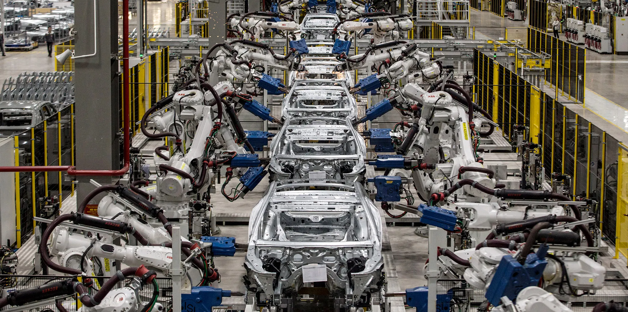 Robotic arms assembling car frames on a high-tech automotive factory line