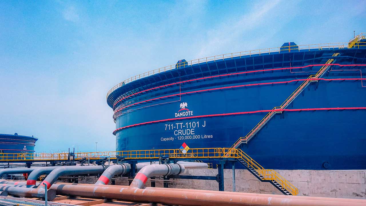Dangote Refinery Crude Oil Storage Tank – Tumisang Bogwasi Large blue crude oil storage tank at the Dangote Refinery with visible pipelines and stairways, labeled with capacity and unit identification.