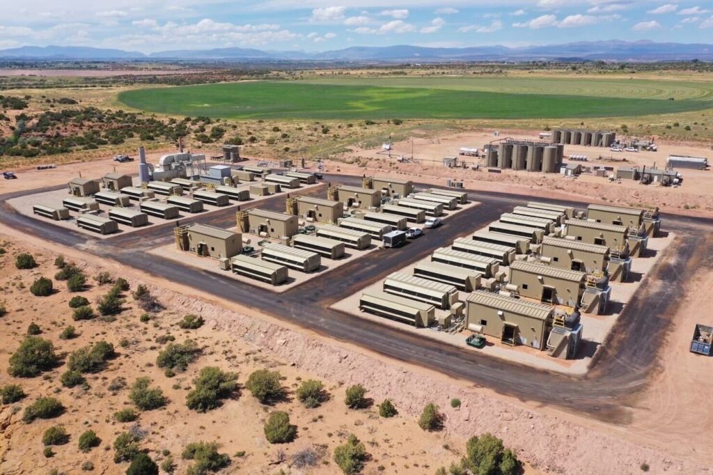 Aerial photograph of a large modular data center facility composed of uniform rectangular units, located in a dry, semi-desert environment.