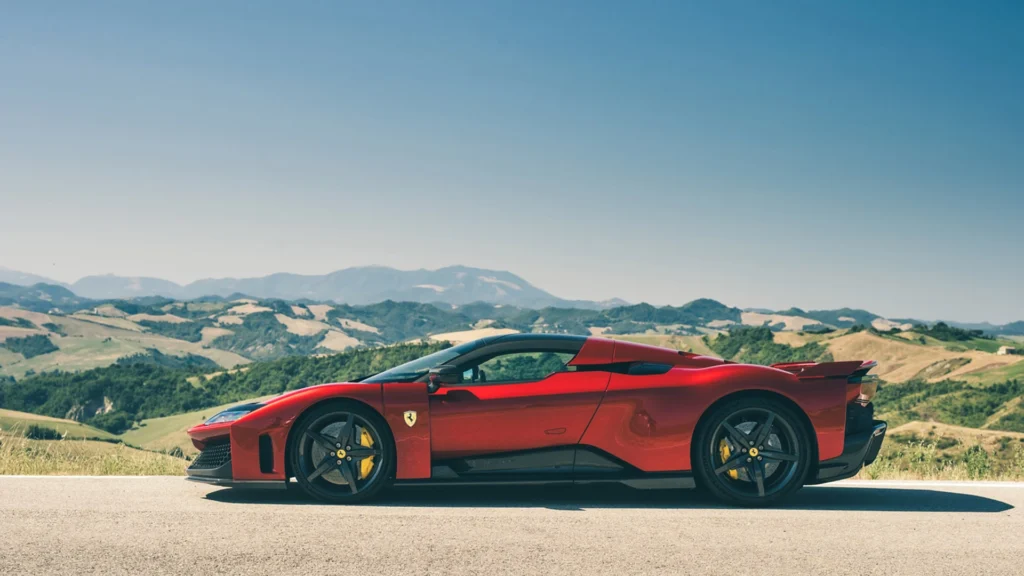 Ferrari F80 in Scenic Mountain Landscape – Tumisang Bogwasi Side view of a red Ferrari F80 parked on a road with green hills and mountains in the background.