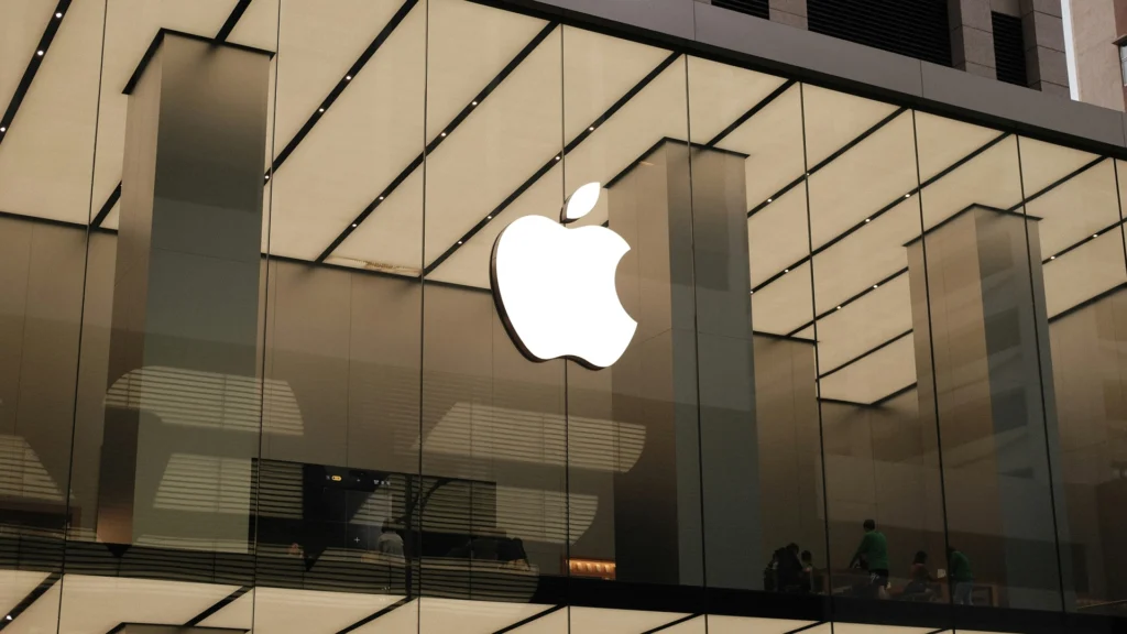 Large illuminated Apple logo displayed inside a modern glass-fronted Apple Store.