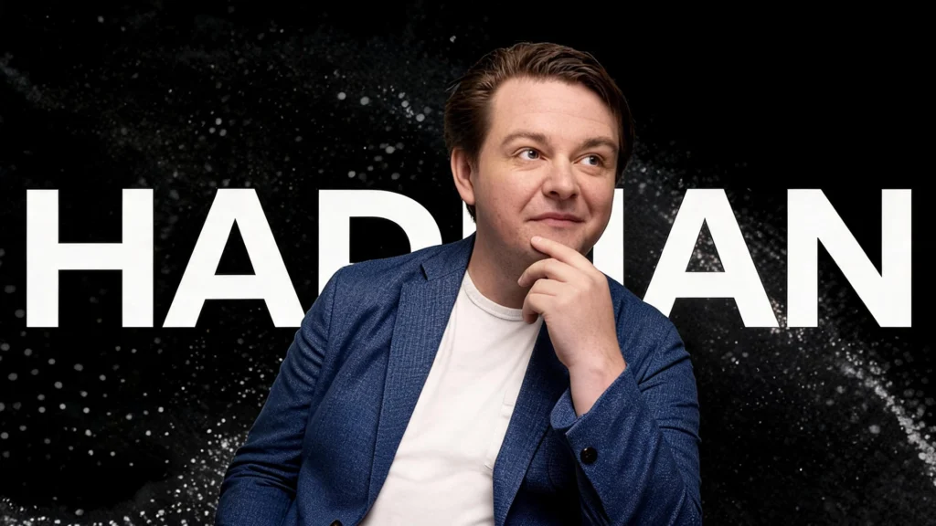 Portrait of Hadrian founder Chris Power seated in front of a dark background with Hadrian branding.
