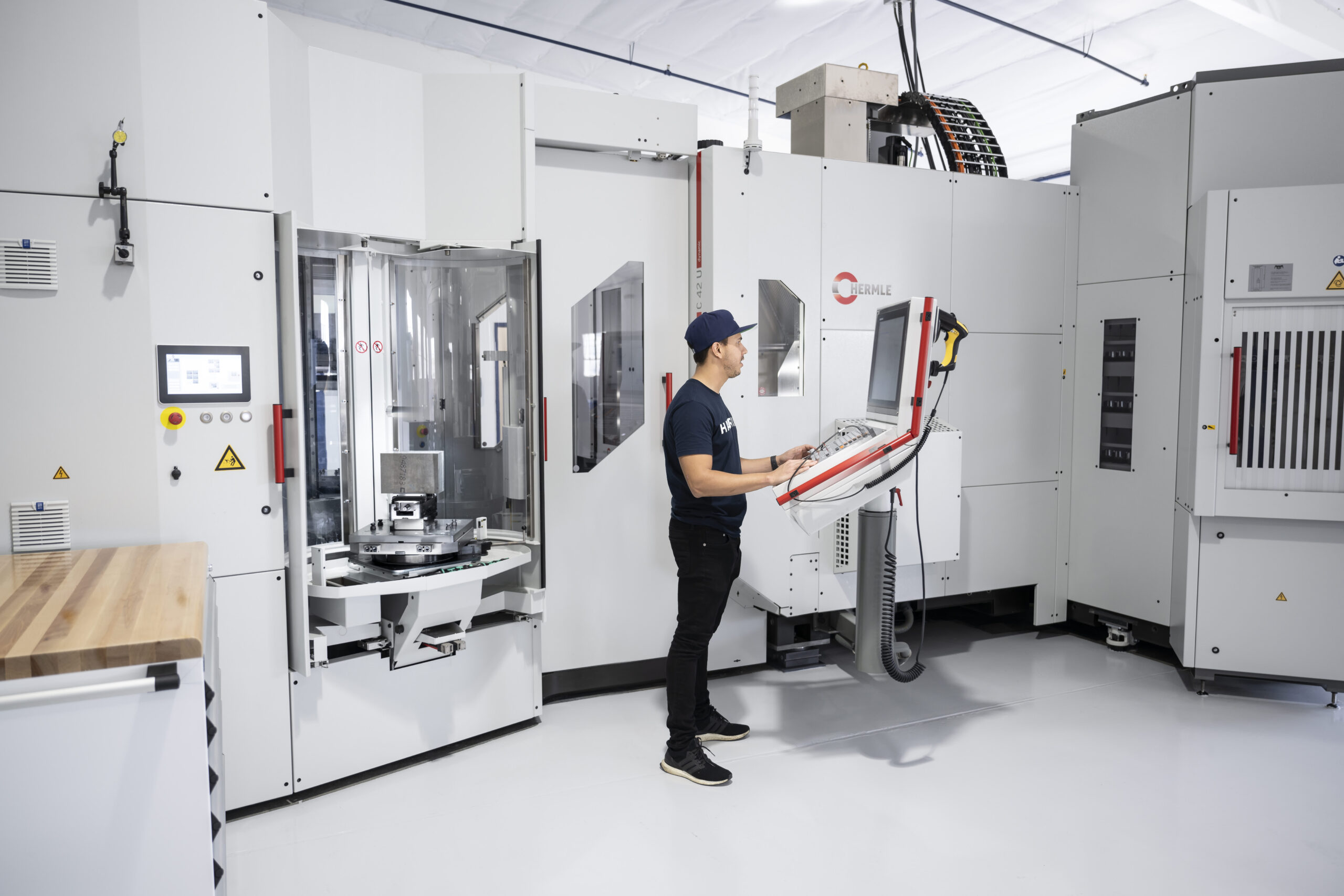 Engineer operating large industrial machining equipment inside Hadrian’s automated factory facility in Hawthorne, California.