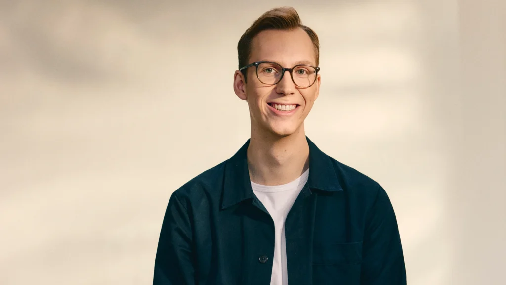 Max Junestrand Founder and CEO of Legora – Tumisang Bogwasi Portrait of Max Junestrand, founder and CEO of Legora, wearing glasses and a dark jacket while smiling against a neutral background.
