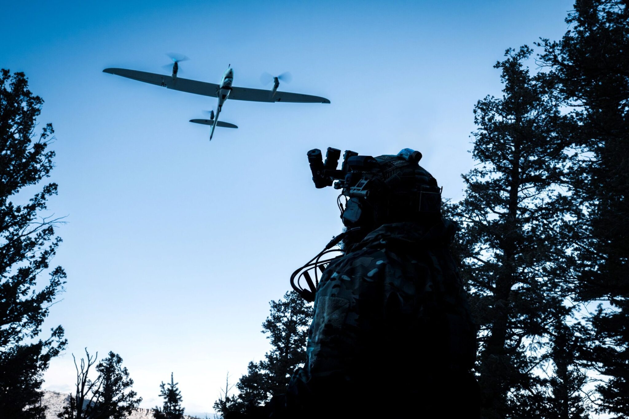 Autonomous Aerial Intelligence in the Field – Tumisang Bogwasi Quantum Systems drone flying above a military operator in a forested environment during an aerial surveillance and reconnaissance mission.