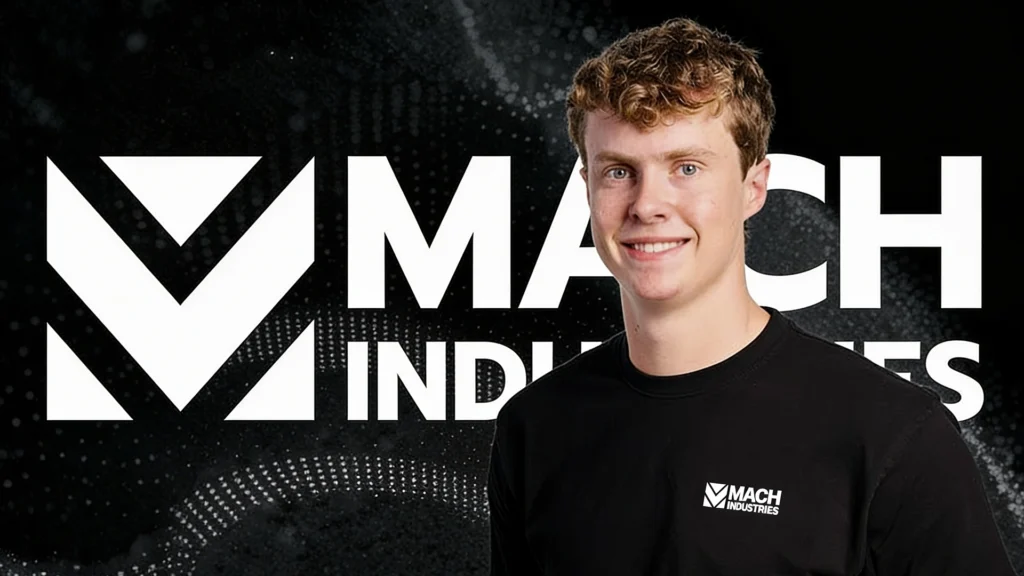 Ethan Thornton Founder and CEO of Mach Industries – Tumisang Bogwasi Ethan Thornton, founder and CEO of Mach Industries, stands in front of the company's logo, smiling toward the camera in a corporate portrait highlighting the defense technology startup.