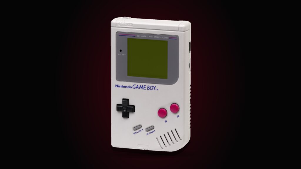 A 1989 Nintendo Game Boy with its grey monochrome screen, photographed against a black background