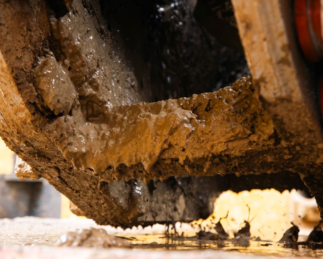 Wet rock cuttings and spoil being cleared from a boring machine
